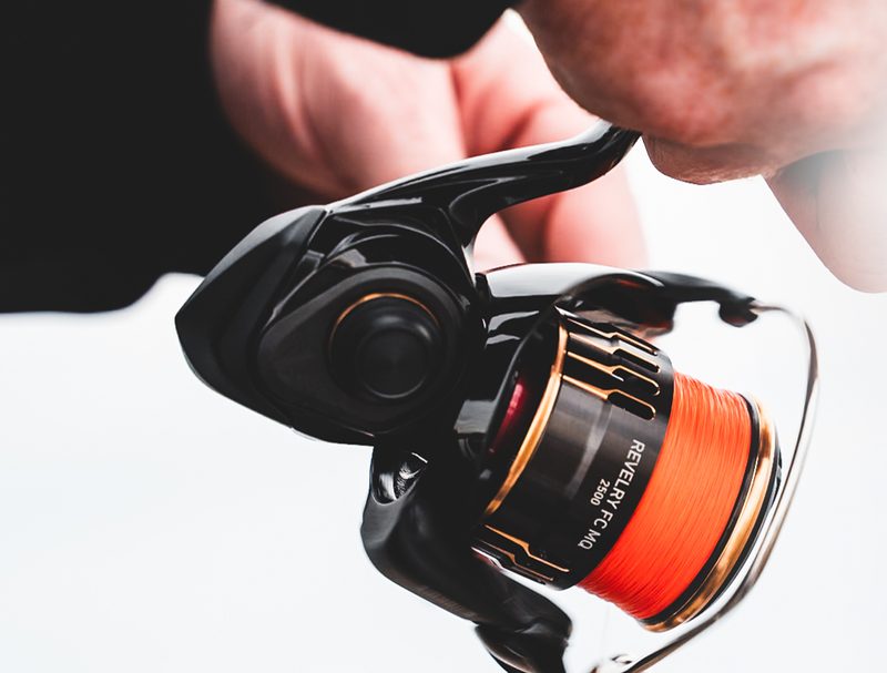 Revelry FC MQ spinning reel spooled with orange braid