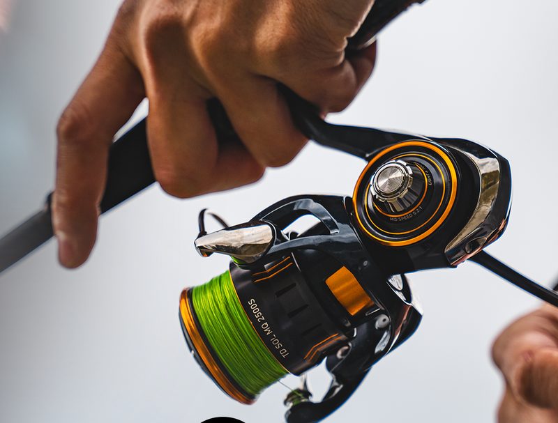 25 TD Sol MQ spinning reel with green braid, in an angler's hands
